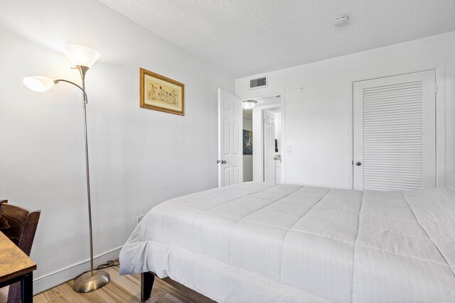 bedroom featuring hardwood / wood-style floors and a textured ceiling