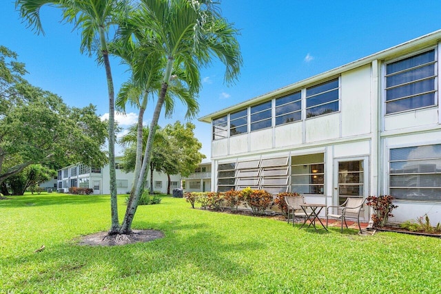 rear view of property featuring a lawn