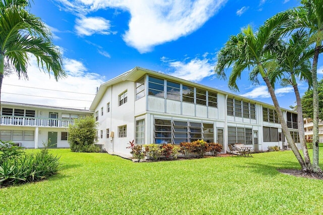 rear view of property with a yard