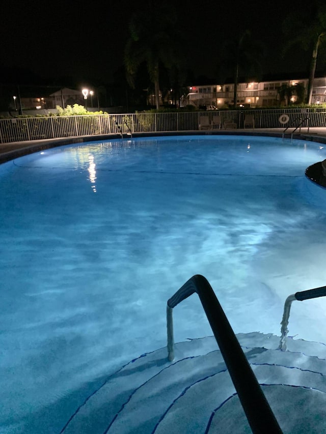 view of pool at twilight