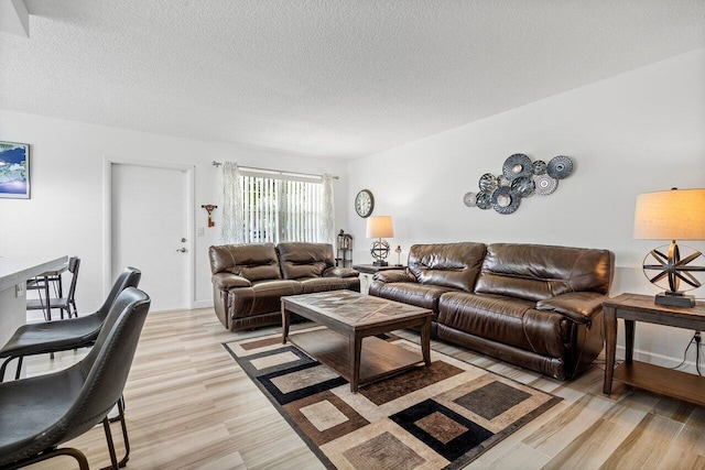 living room featuring light wood-type flooring and a textured ceiling