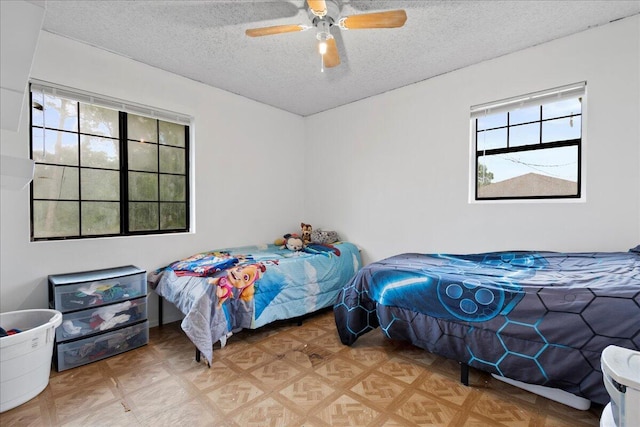 bedroom with a textured ceiling and ceiling fan