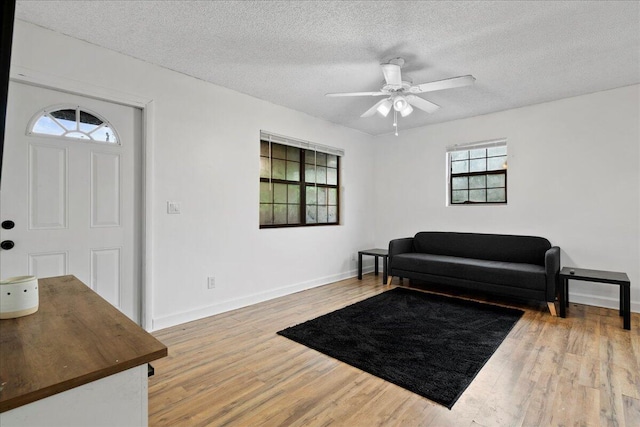 entrance foyer featuring ceiling fan, hardwood / wood-style floors, and a textured ceiling