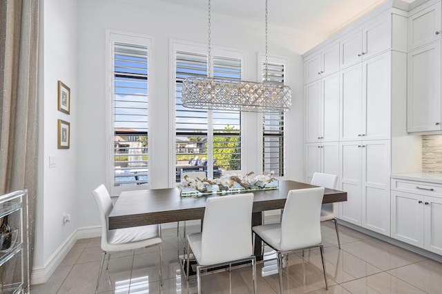 tiled dining room with a chandelier