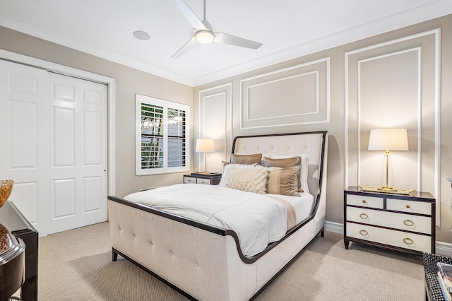 bedroom with ceiling fan, light colored carpet, crown molding, and a closet