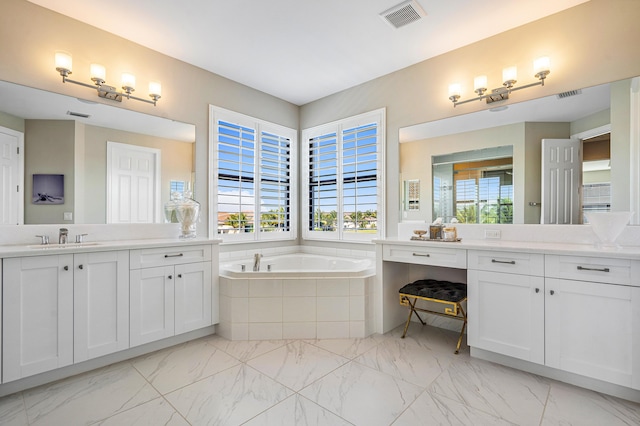 bathroom featuring tiled tub and vanity