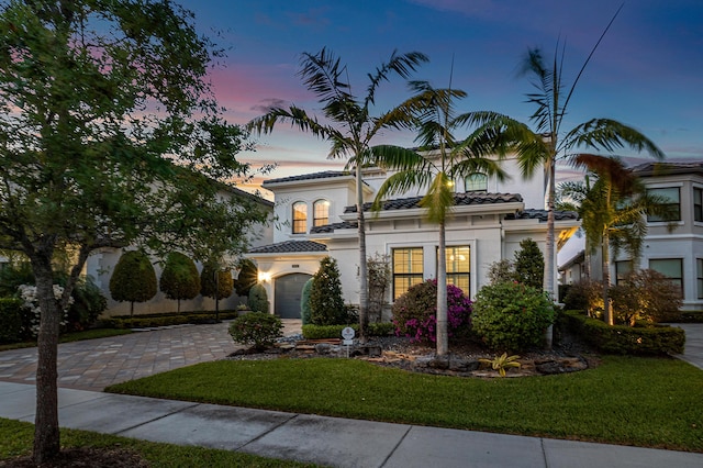 mediterranean / spanish house with a yard and a garage