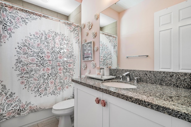 bathroom with tile patterned flooring, vanity, and toilet