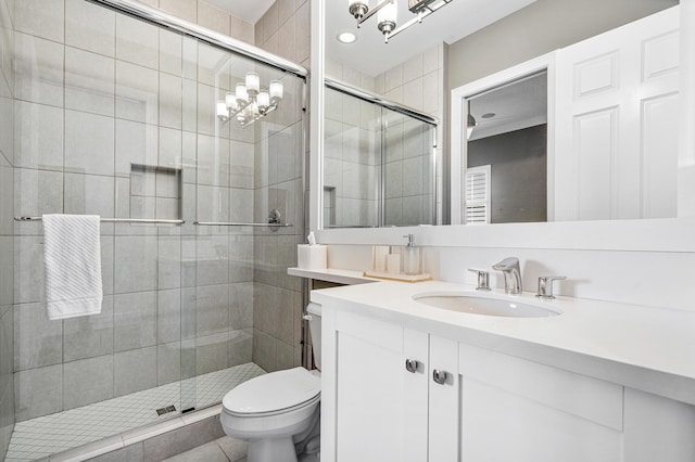 bathroom featuring tile patterned flooring, vanity, toilet, and a shower with shower door