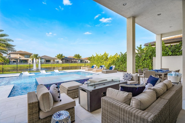 view of swimming pool with a patio area, pool water feature, and an outdoor living space with a fire pit