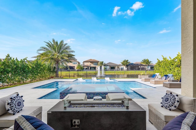 view of swimming pool featuring a patio area and an outdoor living space with a fire pit