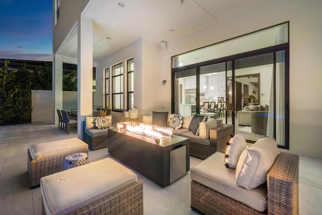 patio terrace at dusk with an outdoor living space with a fire pit