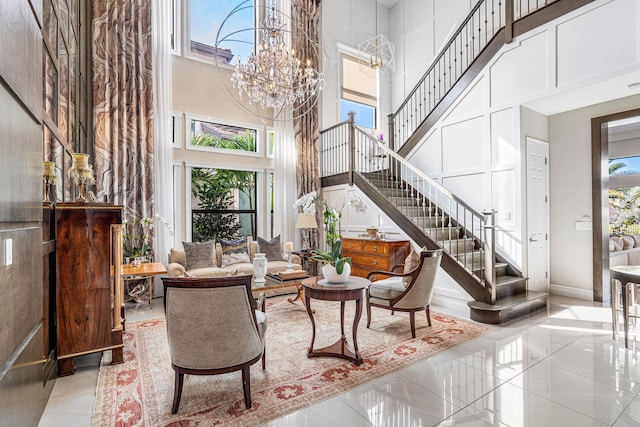 living room with a notable chandelier, plenty of natural light, and a high ceiling