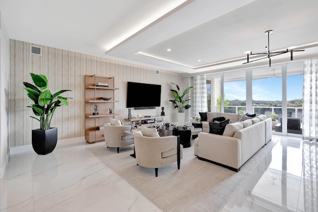 living room featuring a raised ceiling and a notable chandelier