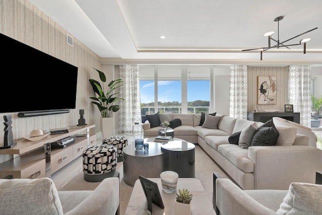 living room with an inviting chandelier and a tray ceiling