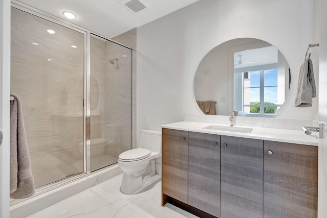 bathroom featuring toilet, ceiling fan, a shower with shower door, and vanity