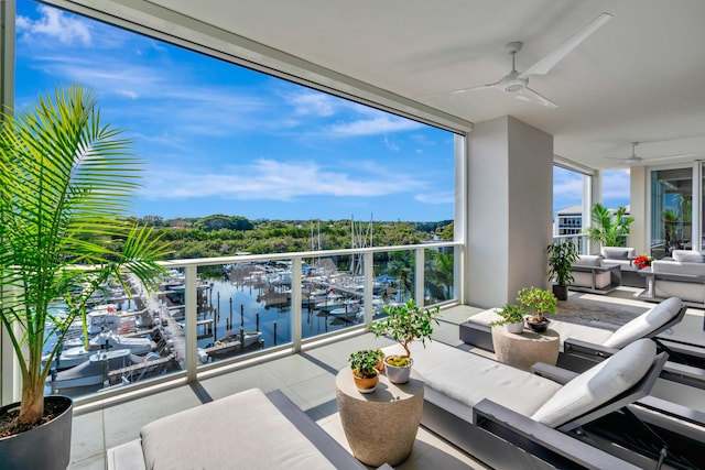 balcony featuring ceiling fan, an outdoor living space, and a water view