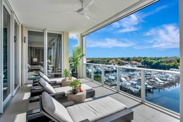 balcony with ceiling fan and a water view