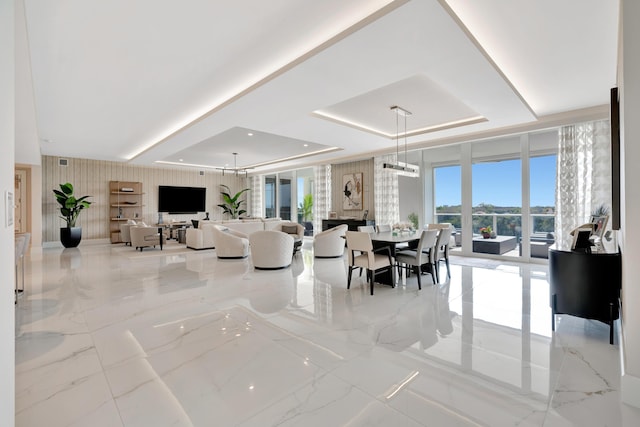 living room featuring a raised ceiling and floor to ceiling windows