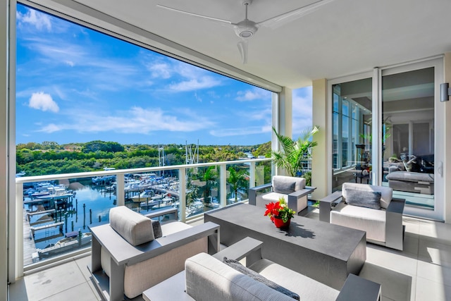 balcony with a water view, ceiling fan, and outdoor lounge area