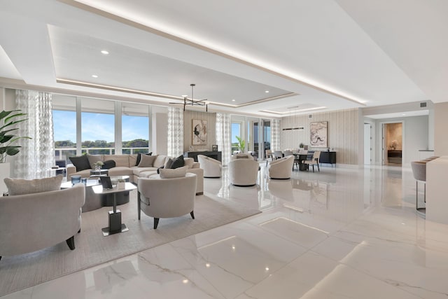 living room featuring a chandelier and a tray ceiling