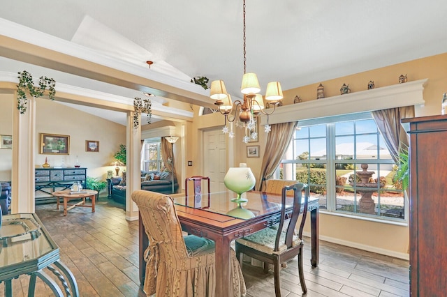 dining space with lofted ceiling and an inviting chandelier