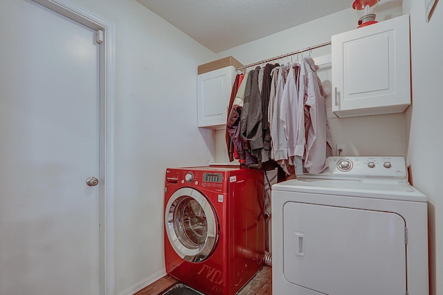 laundry room with cabinets, separate washer and dryer, and wood-type flooring