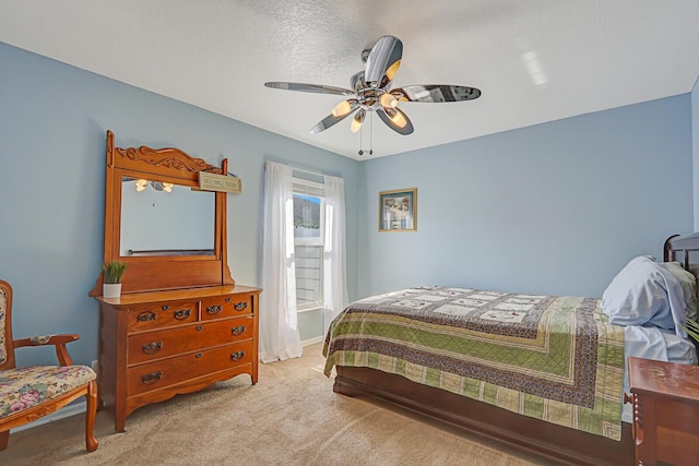 carpeted bedroom with ceiling fan and a textured ceiling