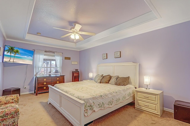 carpeted bedroom with a tray ceiling and ceiling fan