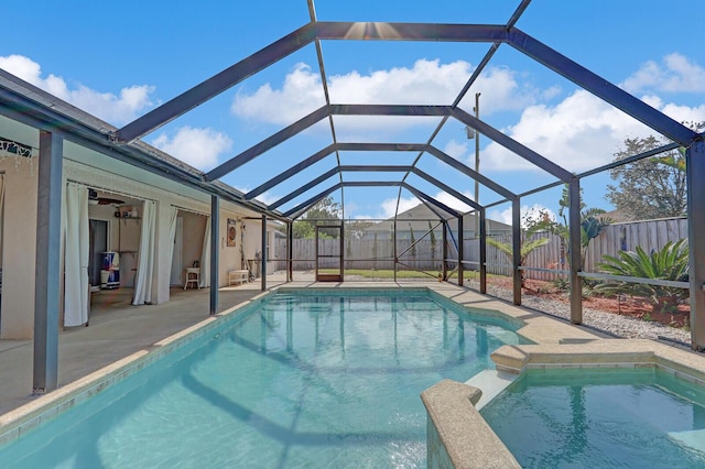 view of swimming pool with glass enclosure and a patio area