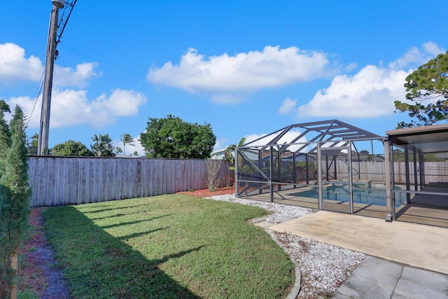 view of yard with a patio, a fenced in pool, and a lanai