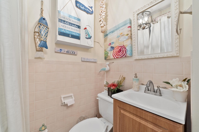 bathroom with vanity, tile walls, and toilet