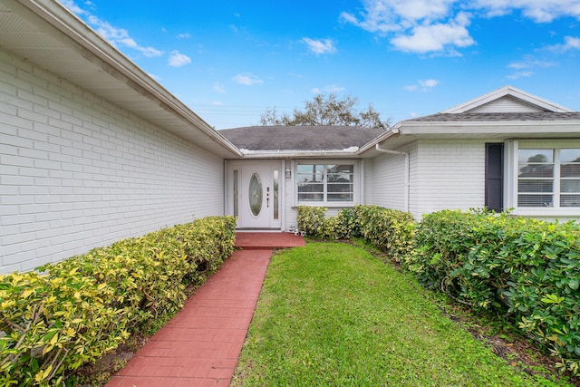 property entrance with a lawn