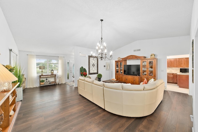 living room with a textured ceiling, dark hardwood / wood-style flooring, a chandelier, and vaulted ceiling