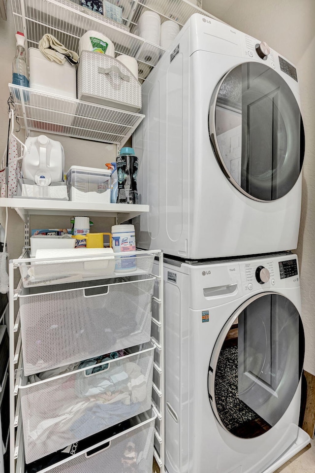 clothes washing area with stacked washer / dryer