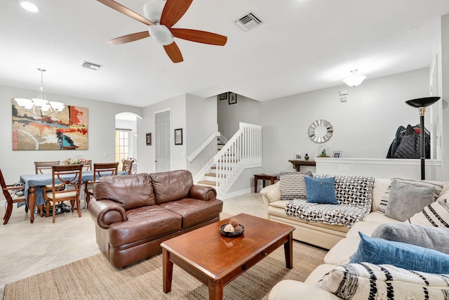 living room featuring ceiling fan with notable chandelier