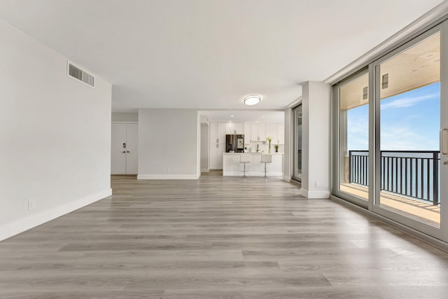 1180 S Ocean Blvd Unit 15B, Boca Raton, FL 33432 - unfurnished living room featuring light wood finished floors and baseboards