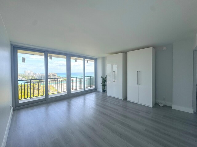 1180 S Ocean Blvd Unit 15B, Boca Raton, FL 33432 - unfurnished room featuring dark wood finished floors, baseboards, a wall of windows, and a water view