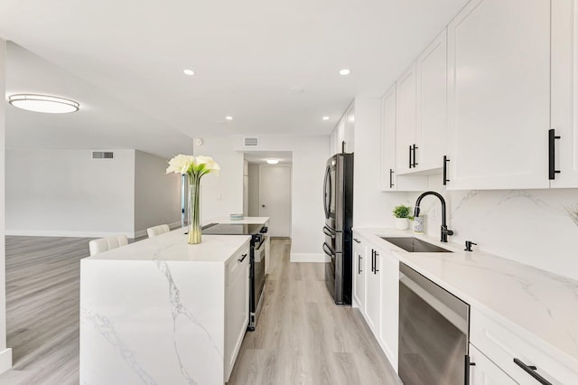1180 S Ocean Blvd Unit 15B, Boca Raton, FL 33432 - kitchen featuring dishwasher, freestanding refrigerator, electric range oven, a kitchen island, and a sink