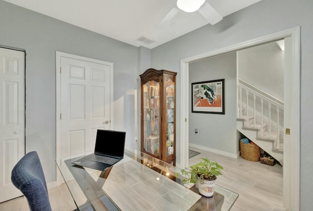 office with light wood-type flooring and ceiling fan