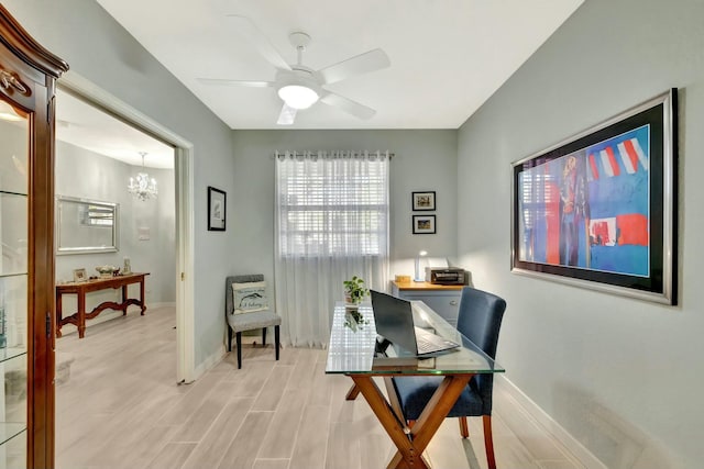 home office with ceiling fan with notable chandelier and light wood-type flooring