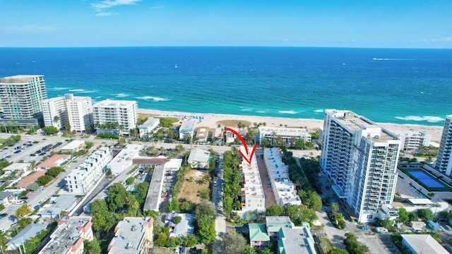 drone / aerial view featuring a beach view and a water view