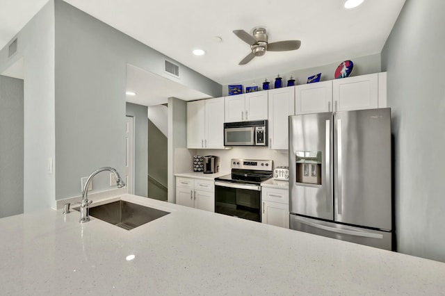 kitchen featuring sink, ceiling fan, light stone countertops, white cabinetry, and stainless steel appliances