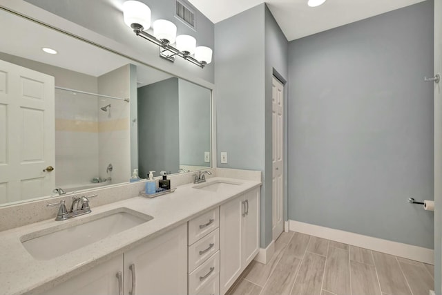 bathroom featuring washtub / shower combination and vanity