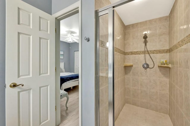 bathroom featuring ceiling fan and a shower with shower door