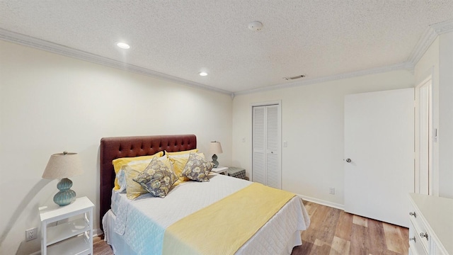 bedroom with a textured ceiling, a closet, and ornamental molding