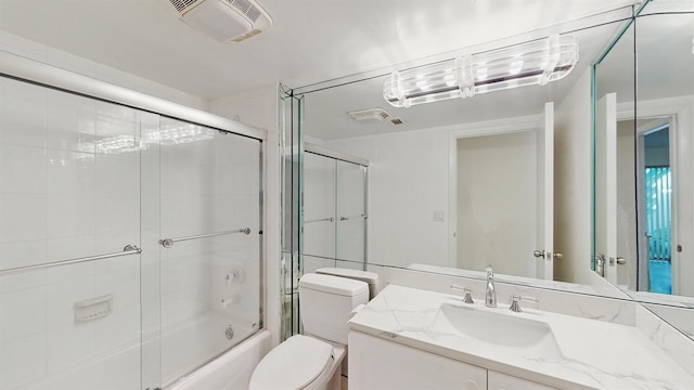 full bathroom featuring toilet, vanity, and shower / bath combination with glass door