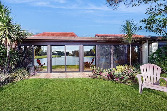 view of yard featuring a water view and a sunroom