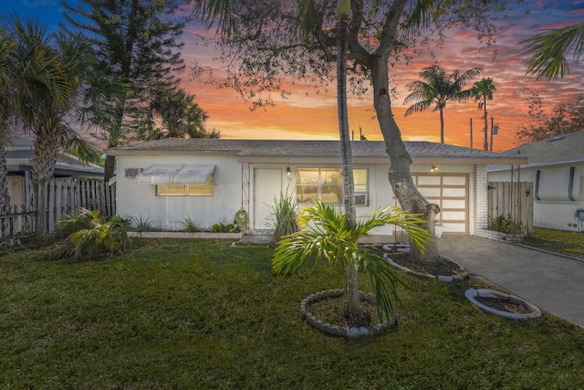 ranch-style home with a yard and a garage