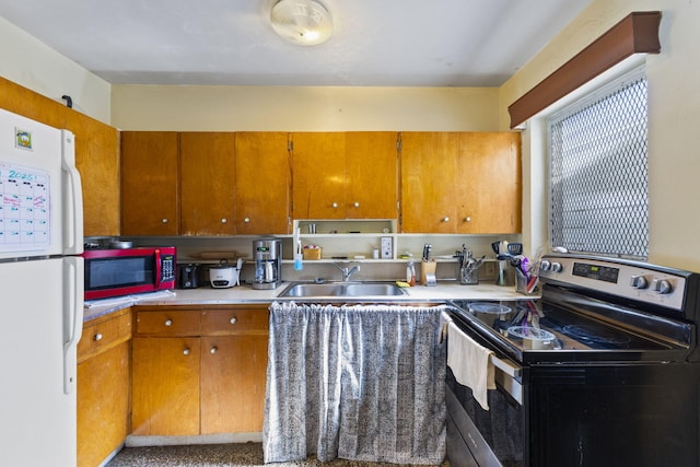 kitchen with white fridge, electric stove, and sink